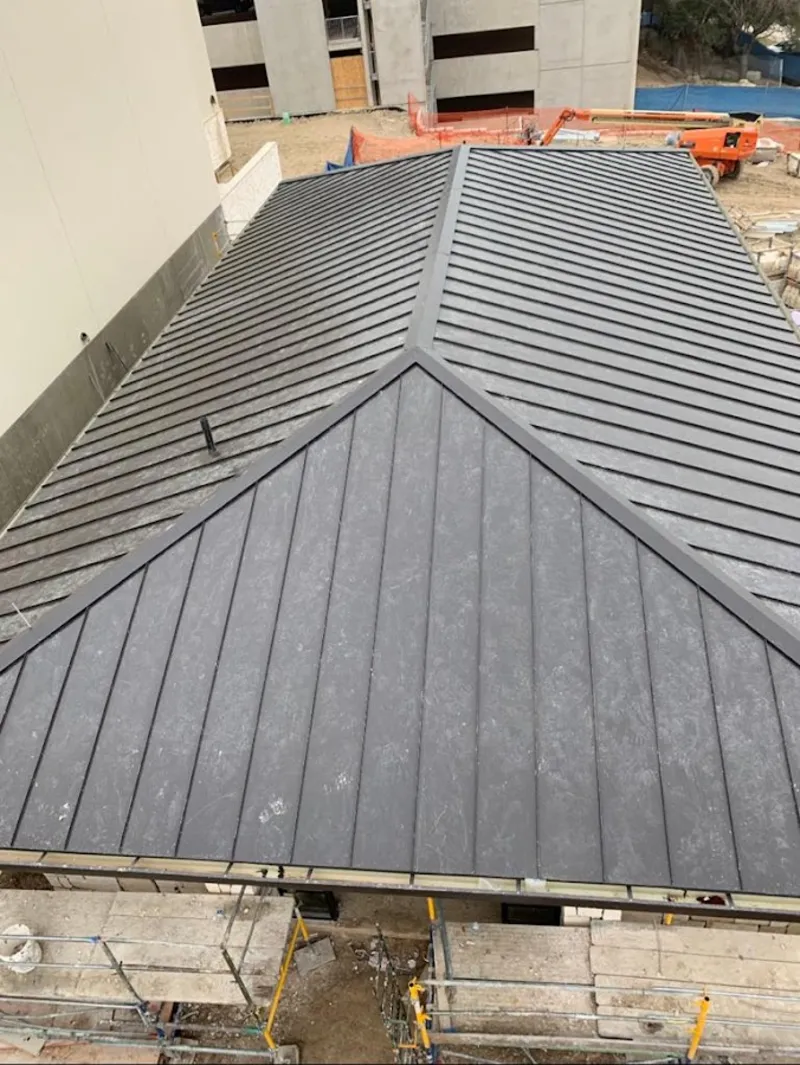 Commercial metal roof construction with crane equipment in Tuba City